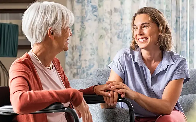 smiling woman and woman in wheelchair